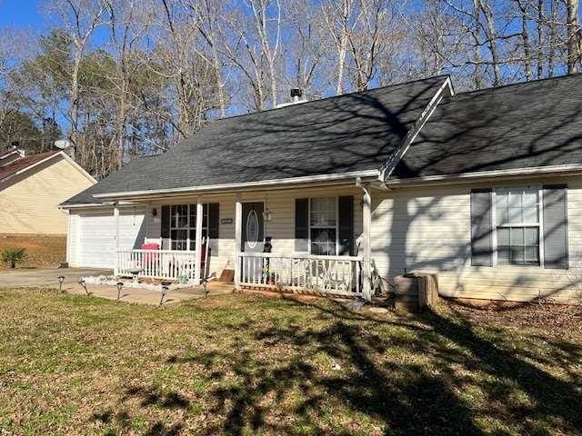 single story home with a garage, covered porch, concrete driveway, and a front yard