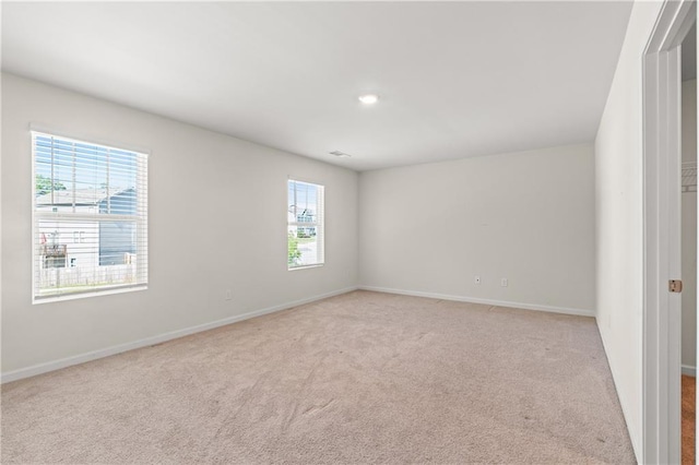 spare room featuring recessed lighting, baseboards, and light carpet