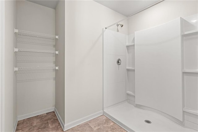 bathroom featuring baseboards and a stall shower