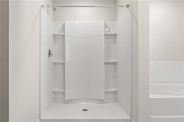 bathroom with a bath and a shower stall