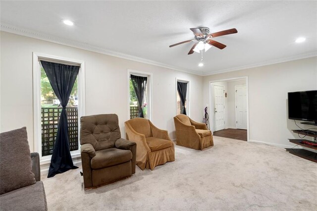 living room with ceiling fan, crown molding, and a healthy amount of sunlight