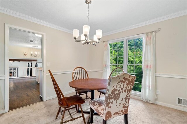 dining room with light carpet, a notable chandelier, and ornamental molding