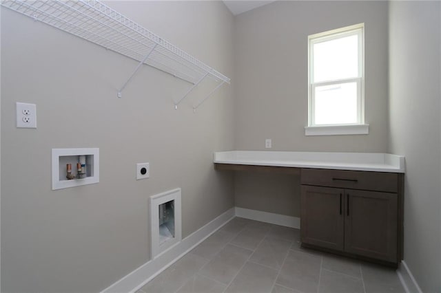 clothes washing area featuring cabinet space, hookup for a washing machine, electric dryer hookup, and baseboards