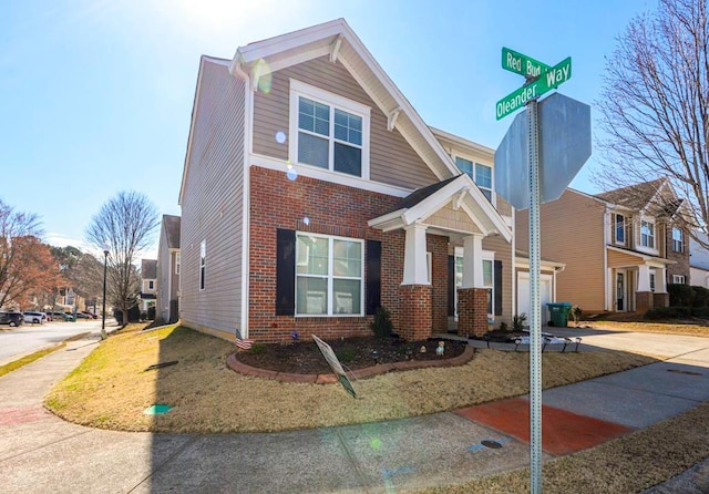 traditional home featuring concrete driveway, brick siding, and an attached garage