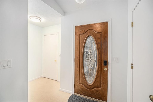 foyer entrance with light colored carpet