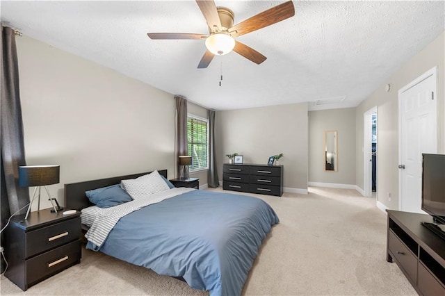 bedroom with baseboards, a ceiling fan, a textured ceiling, and light colored carpet