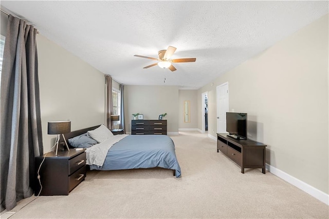 bedroom with light colored carpet, a ceiling fan, baseboards, and a textured ceiling