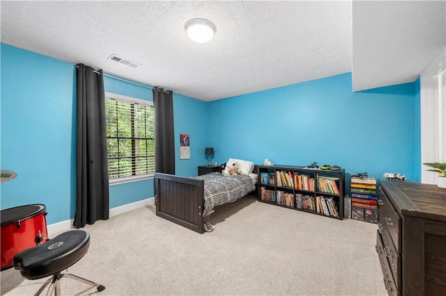 bedroom featuring baseboards, carpet flooring, a textured ceiling, and visible vents