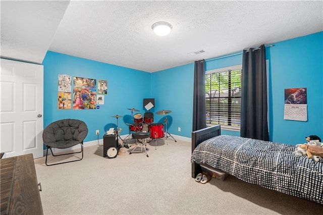 carpeted bedroom with a textured ceiling, baseboards, and visible vents