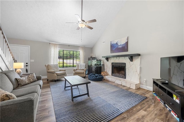 living room with stairway, baseboards, ceiling fan, and wood finished floors