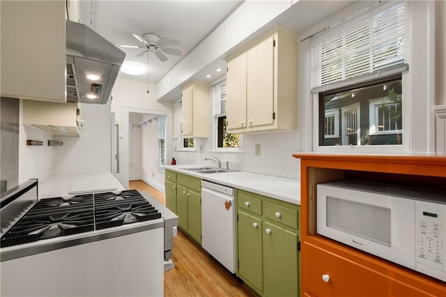 kitchen featuring white appliances, a sink, a ceiling fan, light wood-style flooring, and light countertops