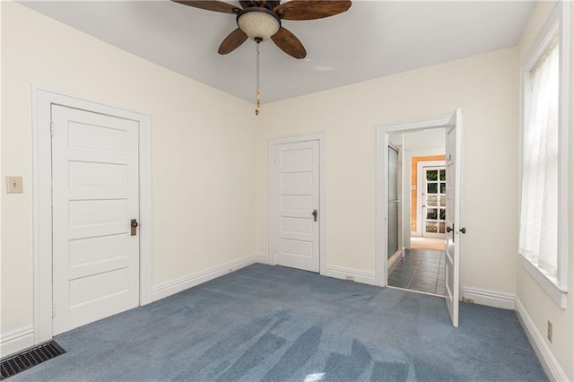 unfurnished bedroom with carpet floors, baseboards, and a ceiling fan