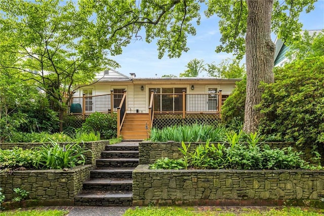 view of front of home with stairs and a deck