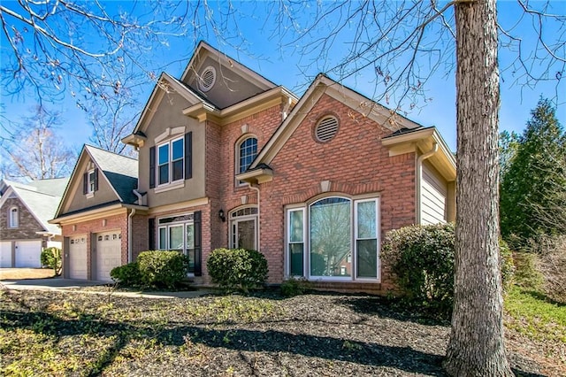 traditional home featuring an attached garage, concrete driveway, and brick siding