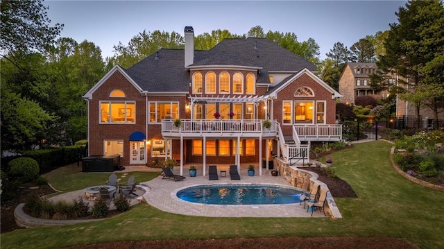 back of property with a covered hot tub, a pergola, a patio area, and a deck