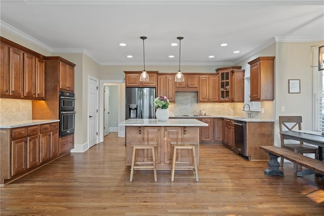 kitchen with dishwashing machine, stainless steel fridge, a sink, brown cabinets, and light wood-style flooring