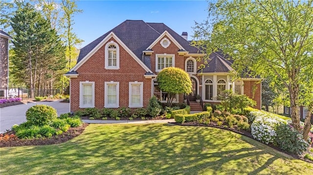 view of front of house with a chimney and brick siding
