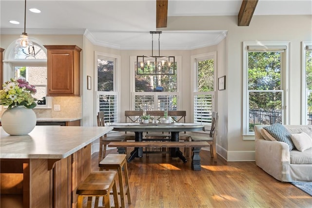 sunroom / solarium featuring healthy amount of natural light, beam ceiling, and a chandelier
