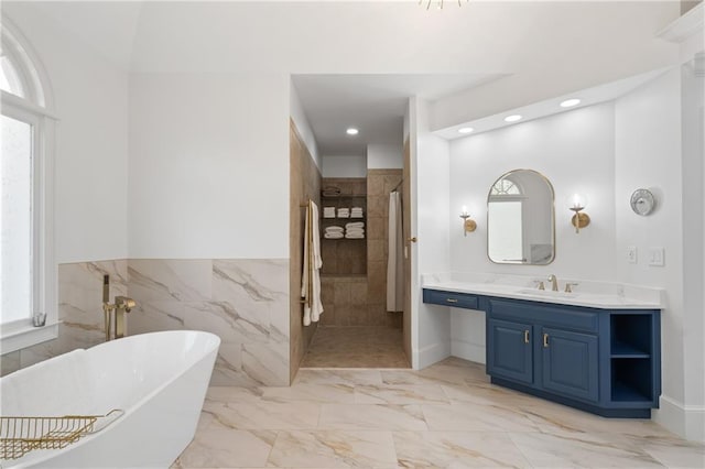 full bath with healthy amount of natural light, a soaking tub, walk in shower, marble finish flooring, and recessed lighting