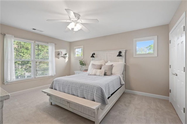 bedroom with light colored carpet, baseboards, and ceiling fan