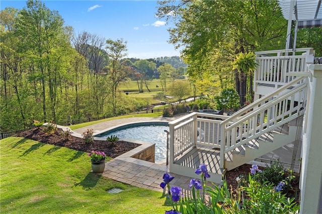 outdoor pool featuring a yard and stairs
