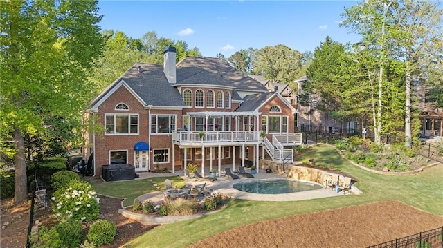 rear view of property with brick siding, a wooden deck, french doors, a patio, and a chimney