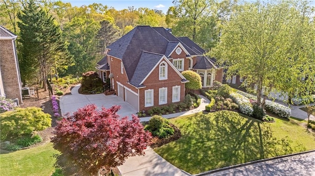 view of front of house featuring concrete driveway, a front lawn, brick siding, a garage, and roof with shingles