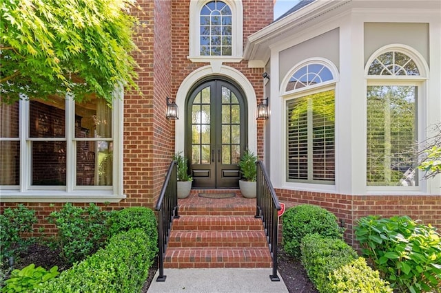 doorway to property featuring french doors and brick siding
