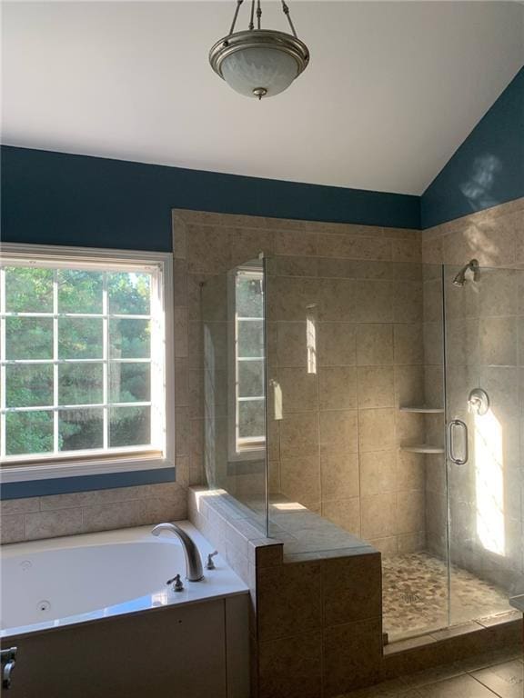 bathroom featuring lofted ceiling, tile patterned flooring, and independent shower and bath