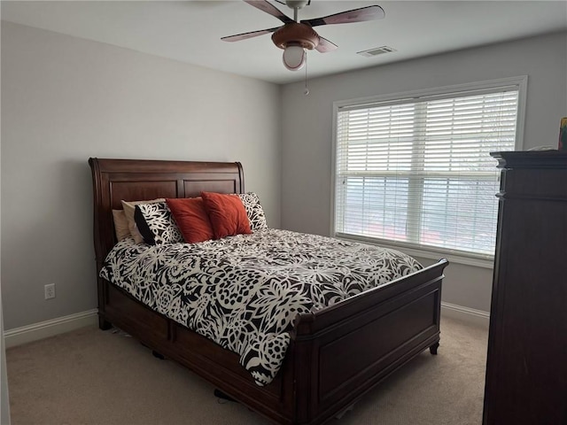 bedroom featuring multiple windows, light colored carpet, and ceiling fan