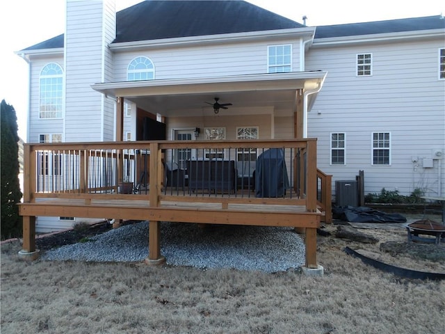 back of property featuring a wooden deck, ceiling fan, an outdoor fire pit, and cooling unit