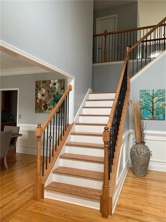 staircase featuring hardwood / wood-style flooring and ornamental molding