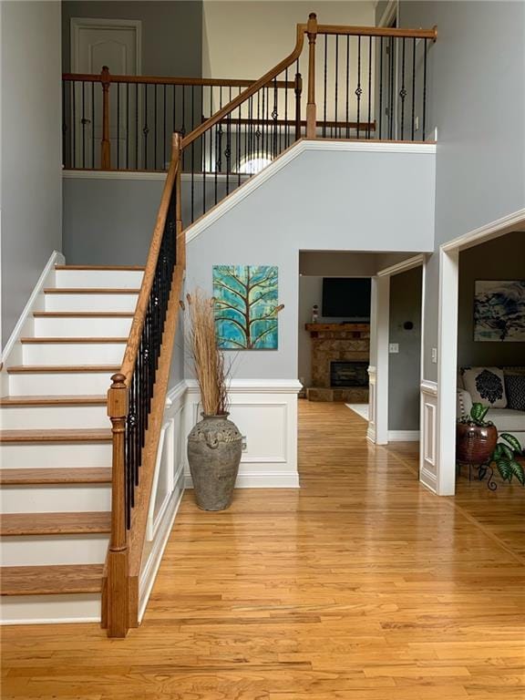 stairs with hardwood / wood-style floors and a towering ceiling