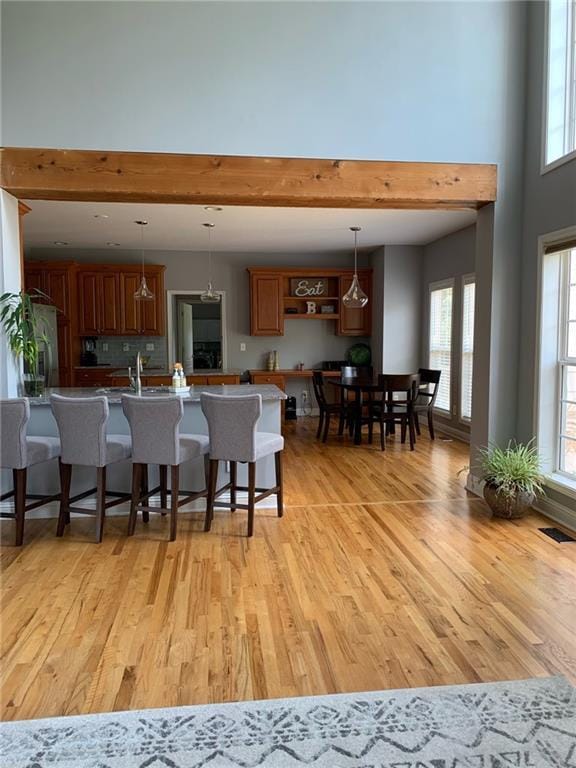 kitchen with pendant lighting, a kitchen breakfast bar, kitchen peninsula, and light wood-type flooring