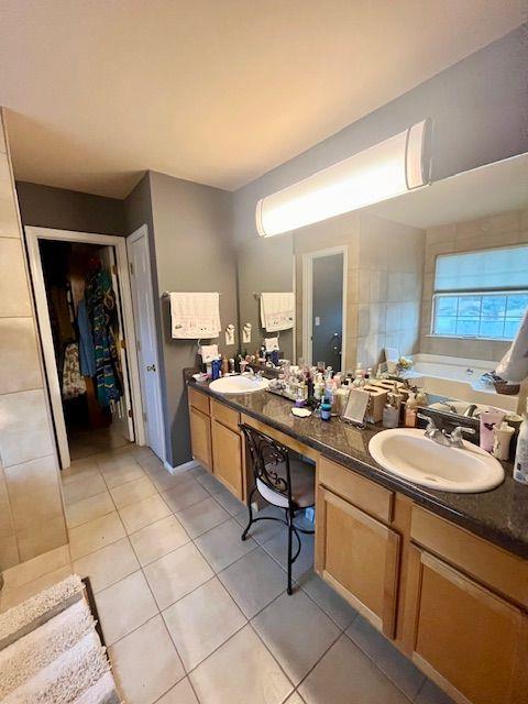 bathroom with tile patterned floors, vanity, and a tub