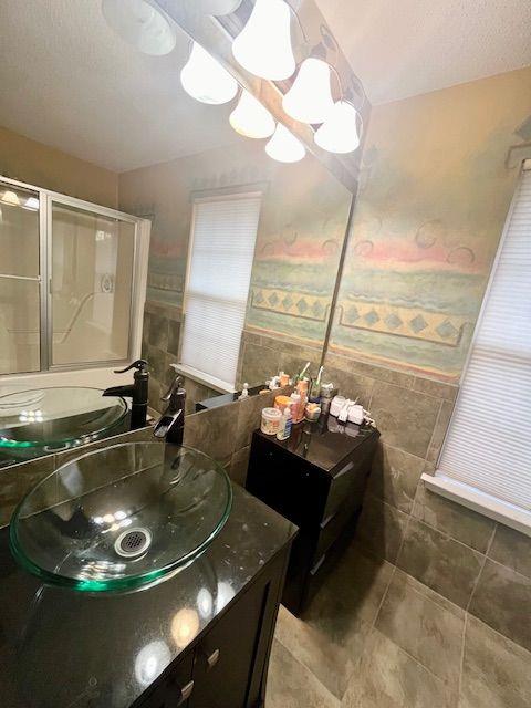 bathroom with vanity, tile walls, and an inviting chandelier