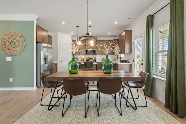 dining area featuring visible vents, crown molding, baseboards, recessed lighting, and light wood-style floors