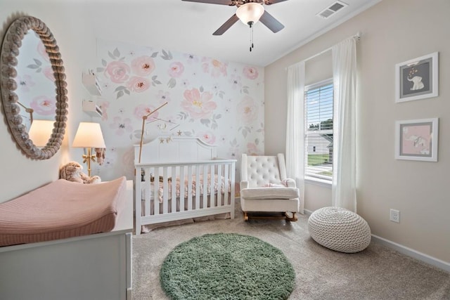 bedroom with carpet, visible vents, baseboards, a ceiling fan, and a crib