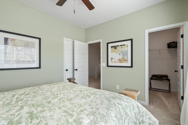 bedroom with a spacious closet, ceiling fan, baseboards, carpet flooring, and a closet