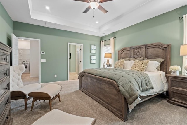 bedroom featuring recessed lighting, a tray ceiling, carpet, and washer / dryer