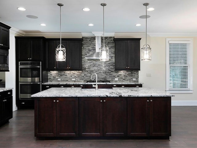 kitchen with pendant lighting, dark hardwood / wood-style floors, a kitchen island with sink, and appliances with stainless steel finishes