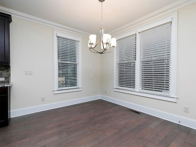 unfurnished dining area featuring crown molding, dark hardwood / wood-style flooring, and a notable chandelier