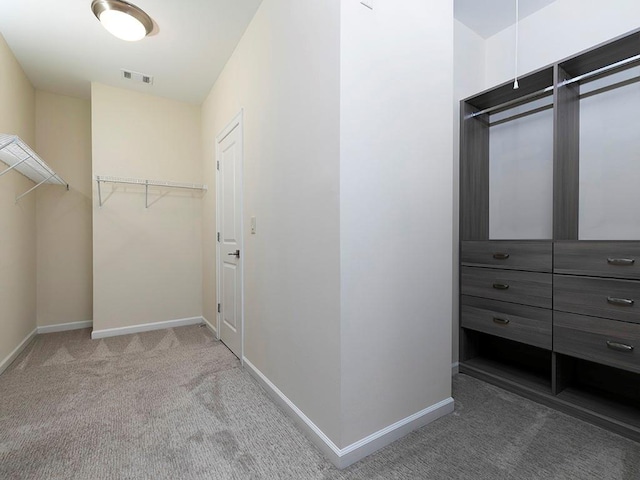 walk in closet featuring light colored carpet