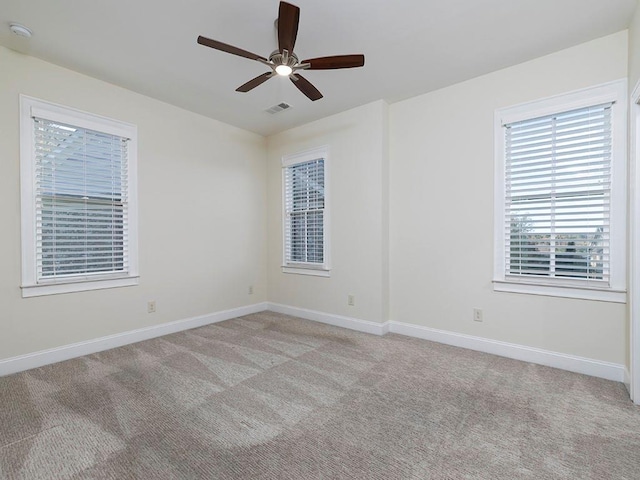 carpeted spare room featuring ceiling fan