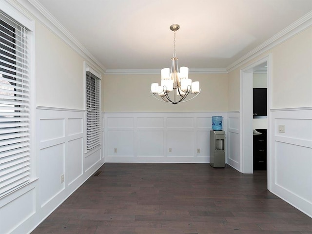 unfurnished dining area with a notable chandelier, crown molding, and dark wood-type flooring