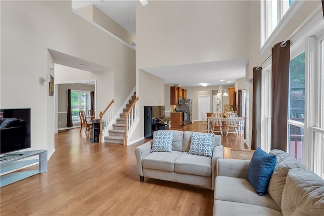 2810 Olde Town Park Dr, Norcross, GA 30071 - living area featuring baseboards, stairway, light wood-style flooring, and a towering ceiling