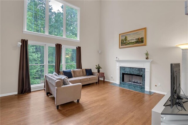 2810 Olde Town Park Dr, Norcross, GA 30071 - living area featuring a fireplace, light wood-style floors, baseboards, and a high ceiling