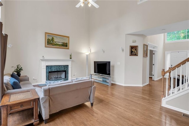 2810 Olde Town Park Dr, Norcross, GA 30071 - living room featuring light wood finished floors, ceiling fan, baseboards, a high end fireplace, and a towering ceiling