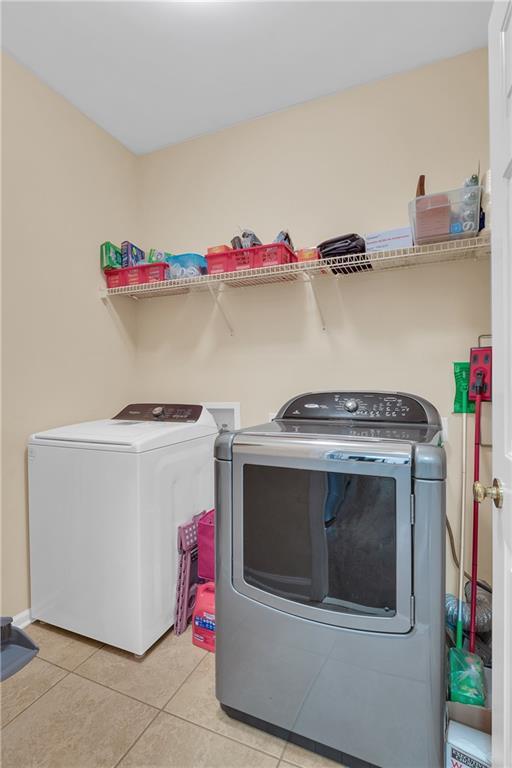 2810 Olde Town Park Dr, Norcross, GA 30071 - clothes washing area with light tile patterned flooring, washing machine and clothes dryer, and laundry area