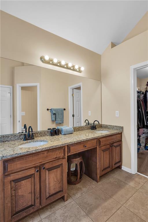 2810 Olde Town Park Dr, Norcross, GA 30071 - full bathroom with tile patterned floors, double vanity, vaulted ceiling, and a sink